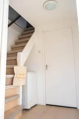 a room with a staircase with a box next to a door at Duinrust in Egmond aan Zee