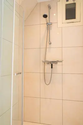 a shower with a glass door in a bathroom at Duinrust in Egmond aan Zee