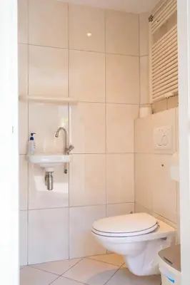 a bathroom with a toilet and a sink at Duinrust in Egmond aan Zee
