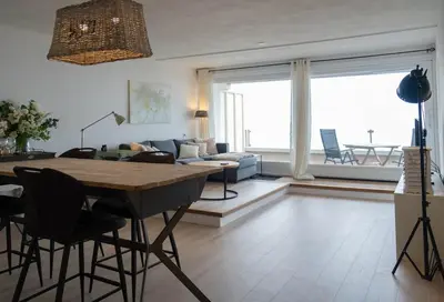 a living room with a table and a couch at Seaviews Egmond in Egmond aan Zee