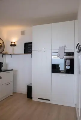 a kitchen with white cabinets and a stove top oven at Seaviews Egmond in Egmond aan Zee