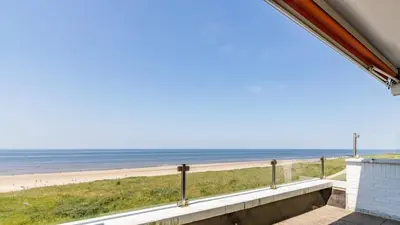 a view of the beach from the balcony of a beach house at Seaviews Egmond in Egmond aan Zee
