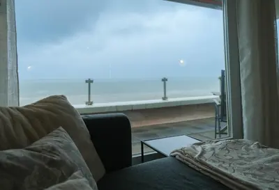 a living room with a couch and a view of the ocean at Seaviews Egmond in Egmond aan Zee