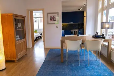 a kitchen with a wooden table and white chairs at Verdronkenoord57 in Alkmaar