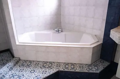 a bath tub in a bathroom with a tile floor at Verdronkenoord57 in Alkmaar