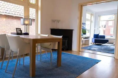 a dining room with a table and white chairs at Verdronkenoord57 in Alkmaar