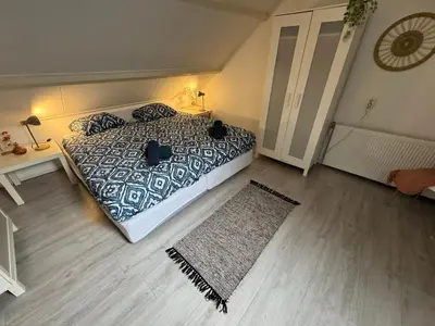 a bedroom with a bed and a rug at Zon Zee en Duin Egmond Strandhuisje in Egmond aan Zee