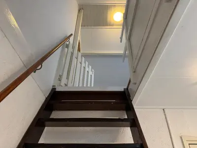 a staircase in a building with a stair case at Zon Zee en Duin Egmond Strandhuisje in Egmond aan Zee
