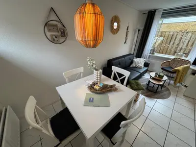a white table and chairs in a living room at Zon Zee en Duin Egmond Strandhuisje in Egmond aan Zee