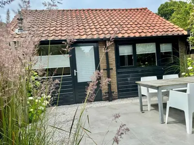 a cottage with a table and chairs in front of it at Private Tiny House in Bussum near Amsterdam! in Bussum