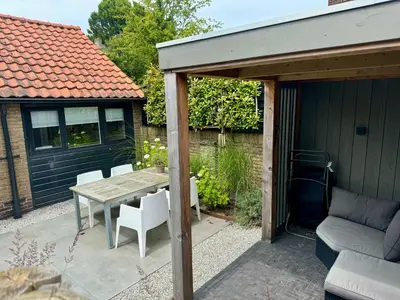 a patio with a table and chairs and a house at Private Tiny House in Bussum near Amsterdam! in Bussum