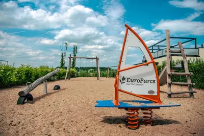 a playground with an orange and white swing set at EuroParcs Bad Hulckesteijn in Nijkerk