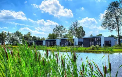a row of modular homes next to a lake at EuroParcs Bad Hulckesteijn in Nijkerk