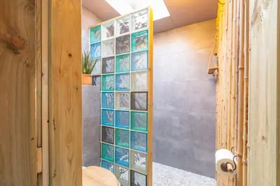 a bathroom with a wall of glass tiles at Vakantiehuisje Casa Calida in Warmenhuizen