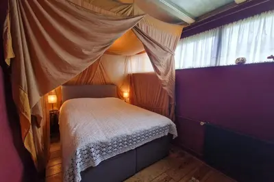 a bedroom with a bed and a window at Vakantiehuisje Casa Calida in Warmenhuizen