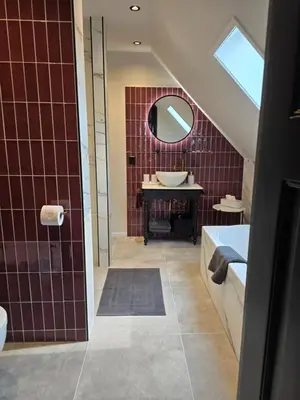 a bathroom with a tub and a sink and a mirror at B&B La Clé Lopik in Lopik