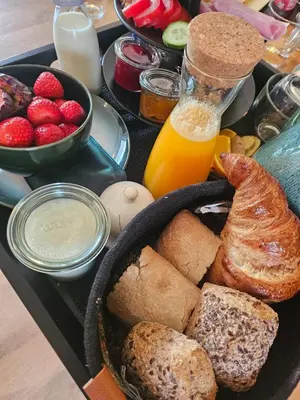 a tray of food with bread and fruit and orange juice at B&B La Clé Lopik in Lopik