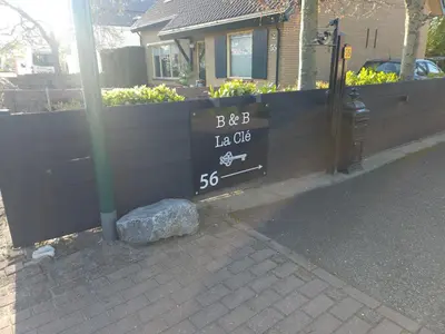 a sign on a fence in front of a house at B&B La Clé Lopik in Lopik