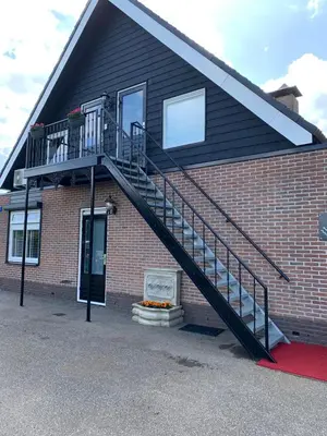 a staircase on the side of a brick building at B&B La Clé Lopik in Lopik
