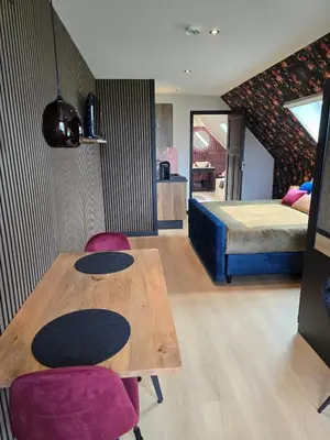 a room with a wooden table and a bed at B&B La Clé Lopik in Lopik