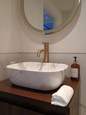 a bathroom with a large white bowl sink and a mirror at Het Haven Huysje in Hoorn