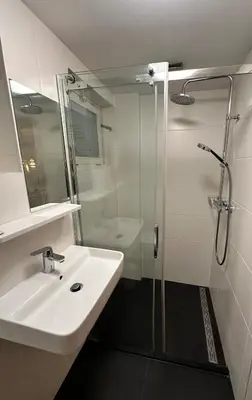 a bathroom with a sink and a glass shower at Cozy Guesthouse 15 min Amsterdam Haarlem Zandvoort in Zwanenburg