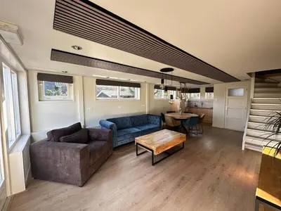 a living room with a couch and a table at Cozy Guesthouse 15 min Amsterdam Haarlem Zandvoort in Zwanenburg
