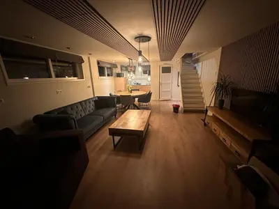 a living room with a couch and a table at Cozy Guesthouse 15 min Amsterdam Haarlem Zandvoort in Zwanenburg