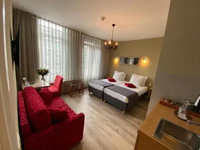 a hotel room with a bed and a red couch at Alp Hotel in Amsterdam