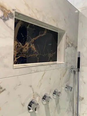 a mirror in a bathroom with marble walls and sinks at Alp Hotel in Amsterdam