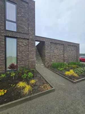 a brick building with two beds of plants at Villa Suite Oudshoorn in Alphen aan den Rijn