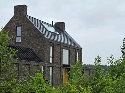 an old brick house with a metal roof at Villa Suite Oudshoorn in Alphen aan den Rijn