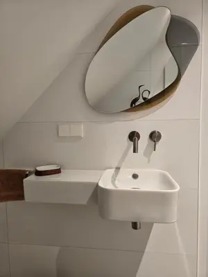 a white bathroom with a sink and a mirror at Villa Suite Oudshoorn in Alphen aan den Rijn