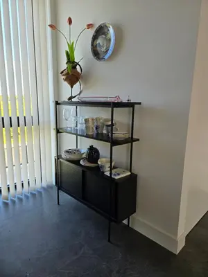a shelf with dishes and a clock on a wall at Villa Suite Oudshoorn in Alphen aan den Rijn