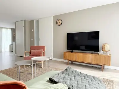 a living room with a flat screen tv on a wall at Vakantiehuis voor mindervaliden op Recreatiepark De Wielen - 61 in Sint Maarten