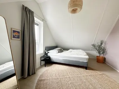 a small bedroom with a bed and a mirror at Vakantiehuis voor mindervaliden op Recreatiepark De Wielen - 61 in Sint Maarten