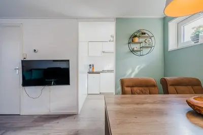 a living room with a table and a television at Vacation home Oase in Egmond aan Zee