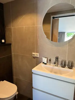 a bathroom with a sink and a mirror at Fazantisch Studio for 2 with private parking in Zandvoort