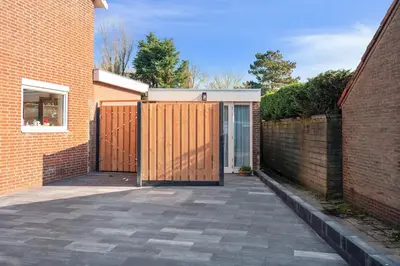 a gate to a house with a brick wall at Fazantisch Studio for 2 with private parking in Zandvoort