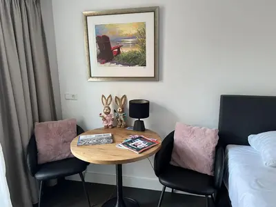 a room with a table and two chairs and a bed at Fazantisch Studio for 2 with private parking in Zandvoort