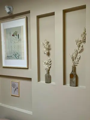 two vases with flowers in them on a wall at Studio Oranje Nassau aan Zee in Zandvoort