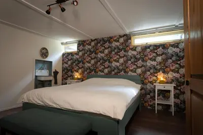 a bedroom with a bed with a floral wallpaper at Boerenvakantie in Hilversum