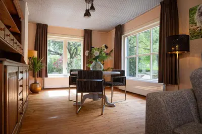 a dining room with a table and some windows at Boerenvakantie in Hilversum