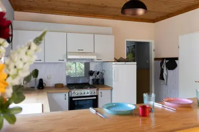 a kitchen with white cabinets and a wooden table at Boerenvakantie in Hilversum