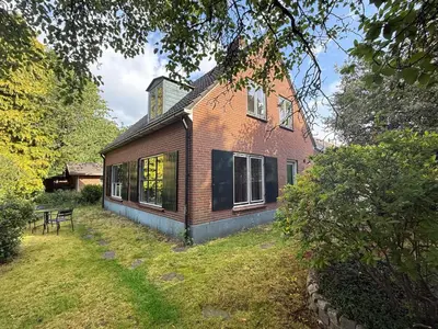 an old brick house with a table in front of it at Boerenvakantie in Hilversum