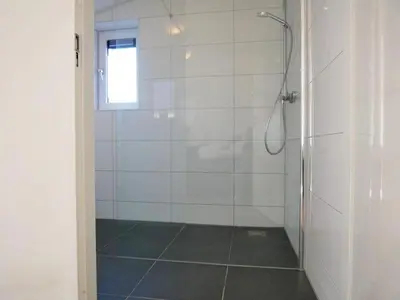 a bathroom with a shower with a glass door at Vakantiehuis met sauna op Recreatiepark de Wielen - 64 in Sint Maarten