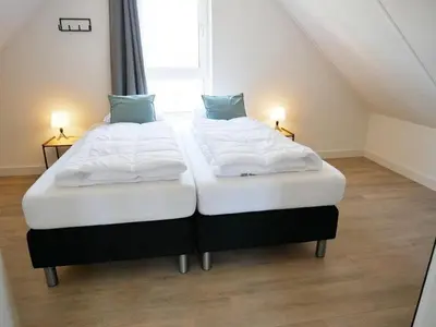 two twin beds in a room with two lamps at Vakantiehuis met sauna op Recreatiepark de Wielen - 64 in Sint Maarten