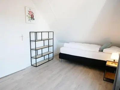 a bedroom with a bed and a book shelf at Vakantiehuis met sauna op Recreatiepark de Wielen - 64 in Sint Maarten