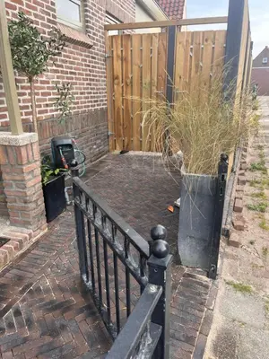 a patio with a fence and a potted plant at Beachhouse Noteboom, omheinde tuin in Noordwijk aan Zee