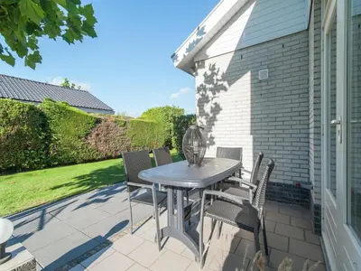 a table and chairs on the patio of a house at Bungalow in South Holland near the Beach in Noordwijk